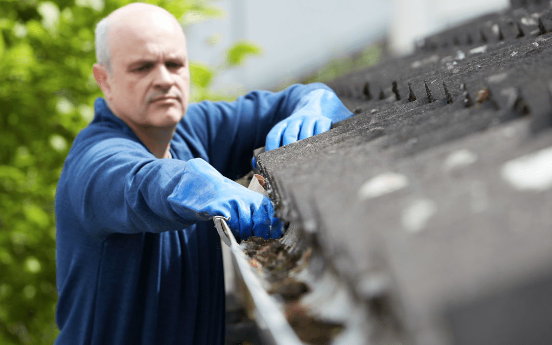 Man cleaning roof gutter