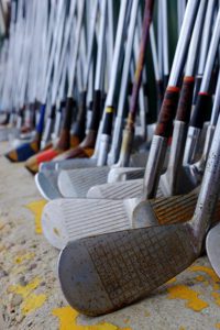Row of used golf clubs lined up