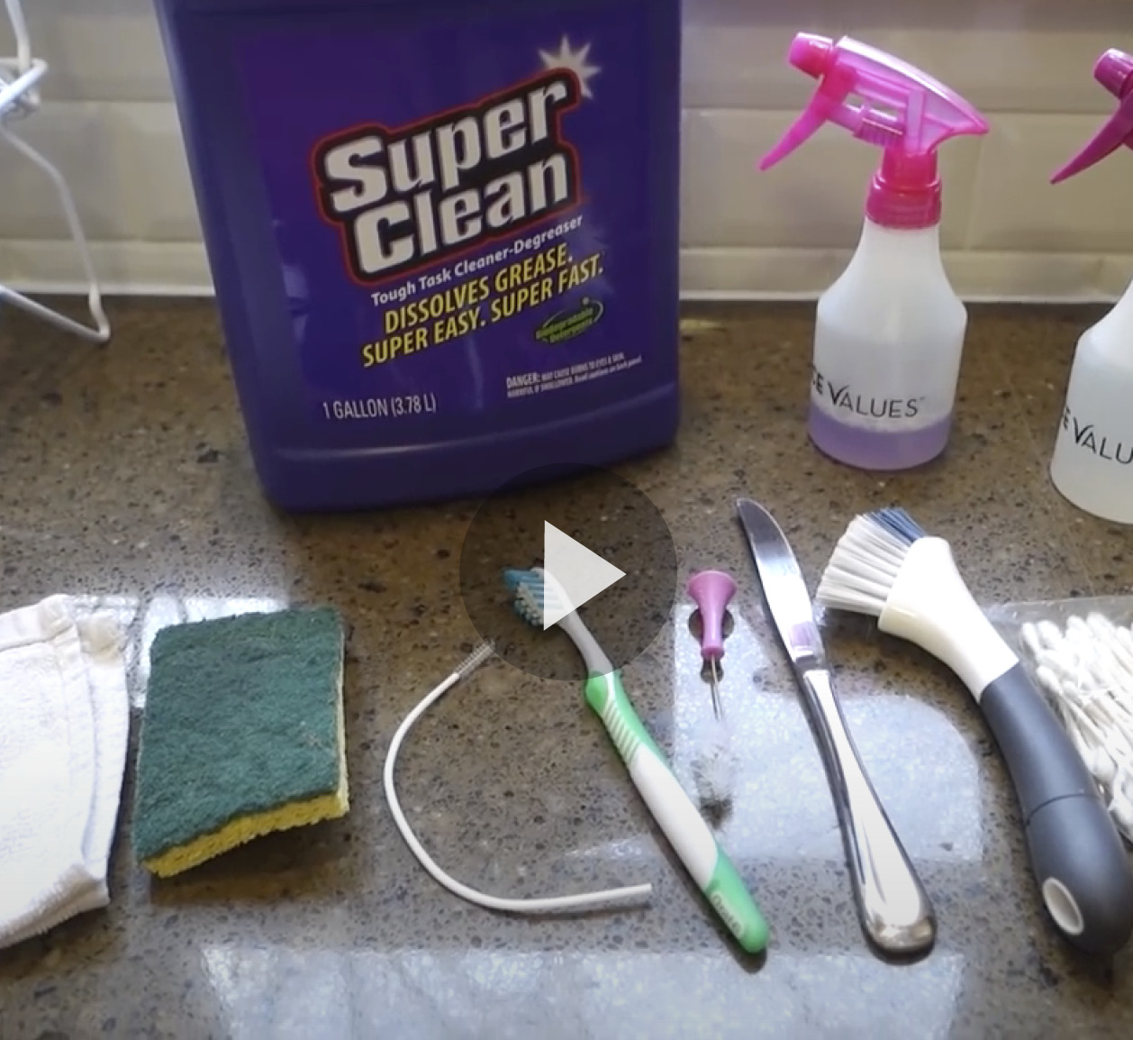 Variety of cleaning tools, spray bottles and bottle of Super Clean
